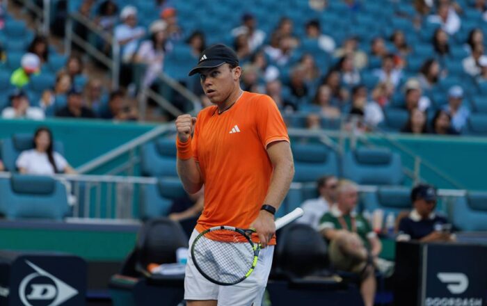 Alex Michelsen clenches his fist to celebrate a point on a hard court