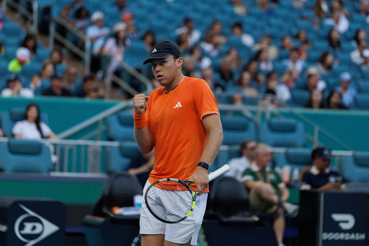 Alex Michelsen clenches his fist to celebrate a point on a hard court