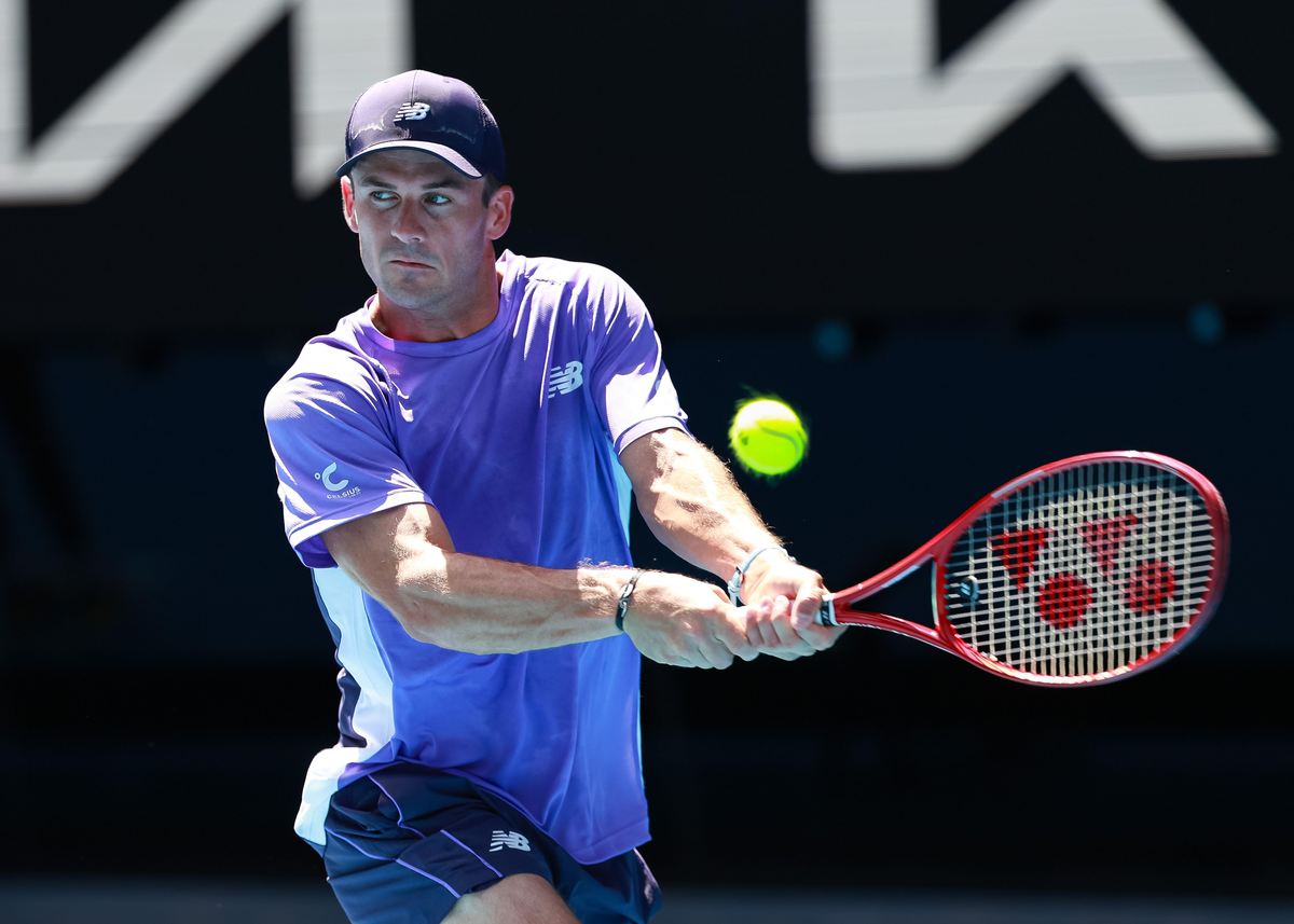 Tommy Paul playing a forehand in a blue kit and cap